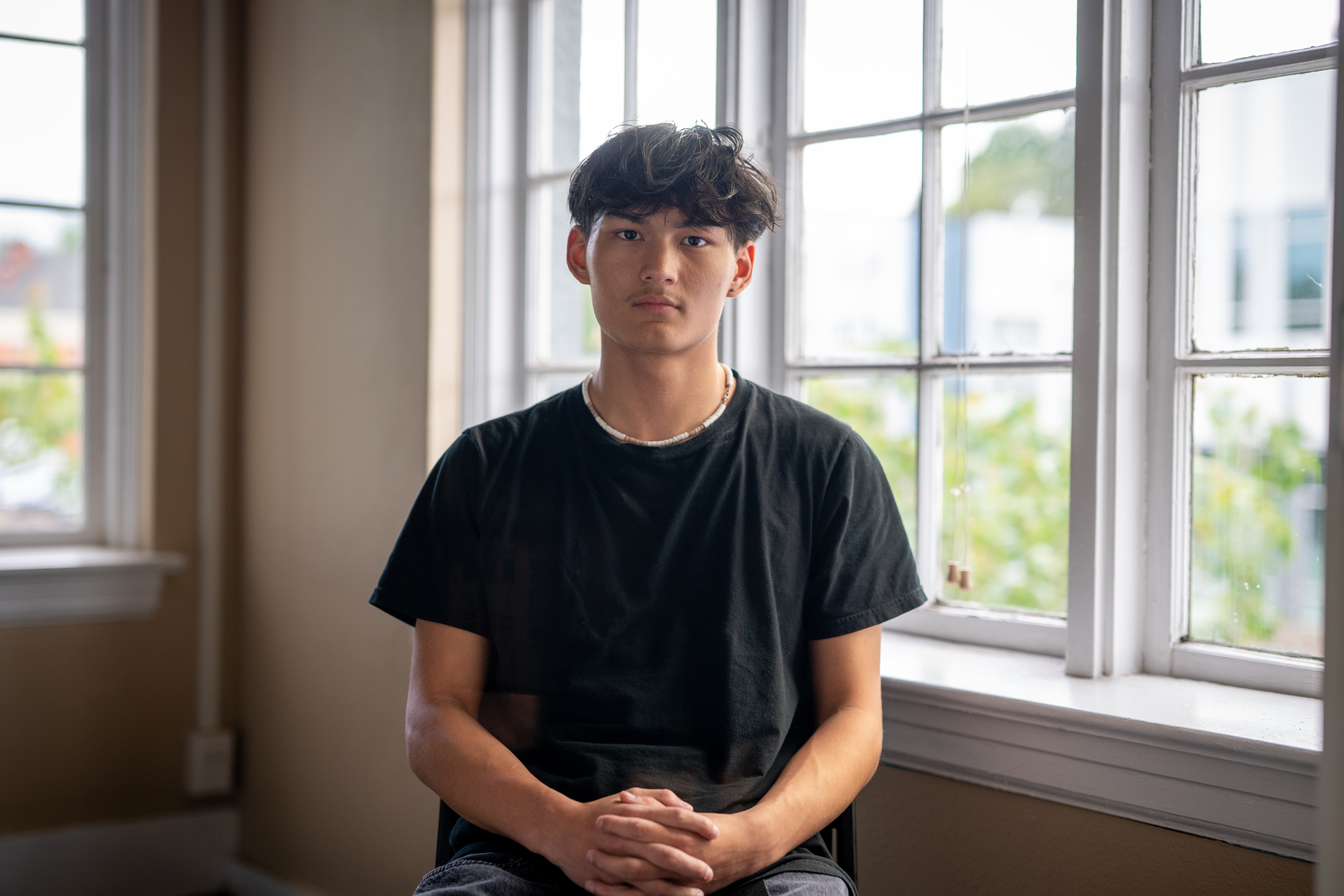 A young person seated for an environmental portrait during Training Camp