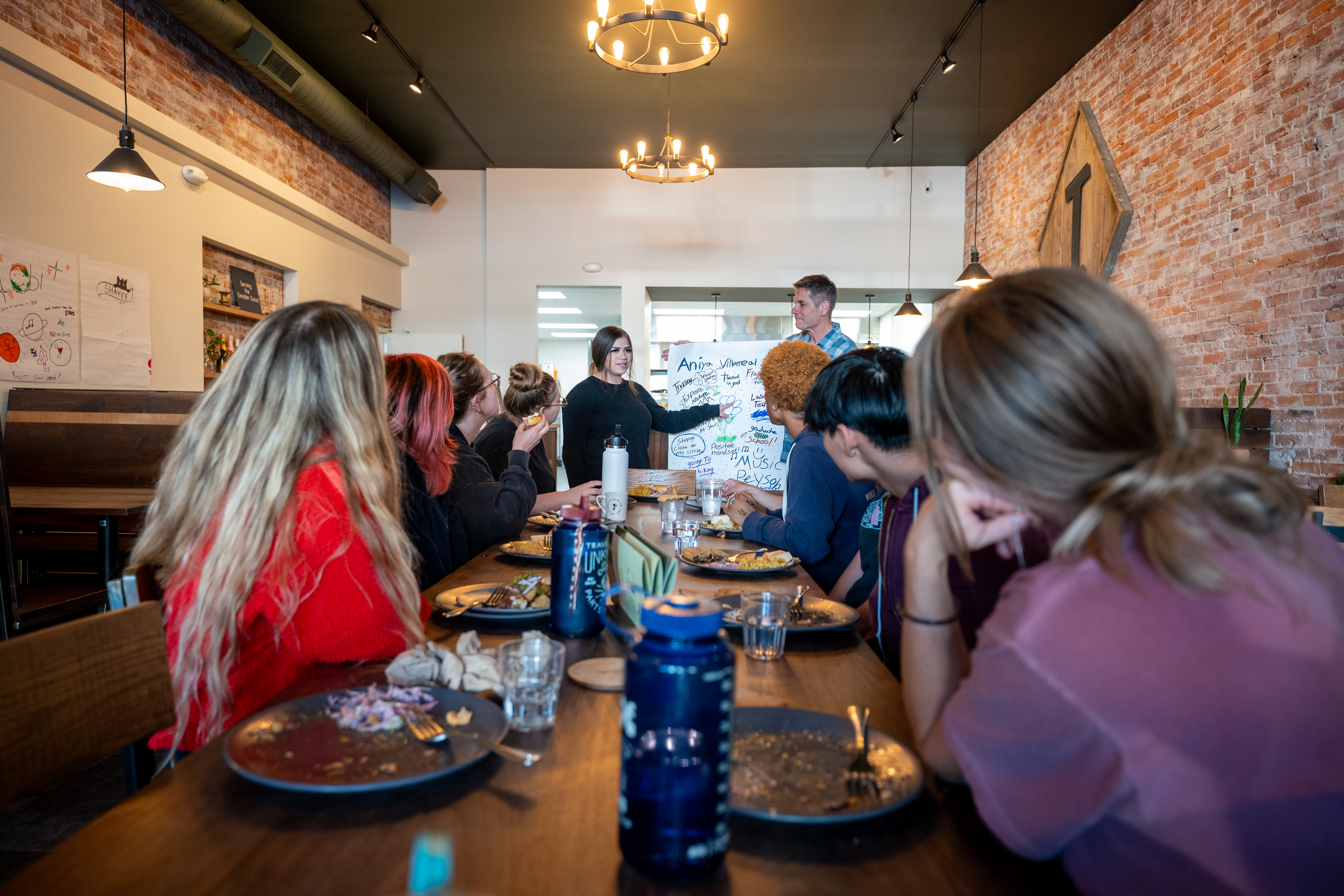 Young people sharing a meal and presenting to one another
